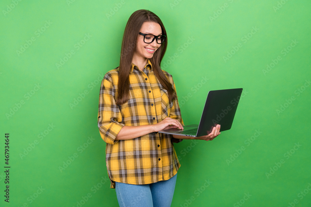 Photo of positive charming lady use laptop receive email have good mood isolated on green color background Photo of positive charming lady use laptop receive email have good mood isolated on green color background