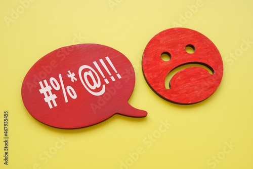 Hate speech or rudeness concept. Unhappy face and quote bubble.