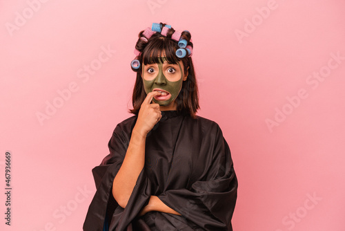 Young mixed race woman waiting in a Beaty salon isolated on pink background relaxed thinking about something looking at a copy space. © Asier