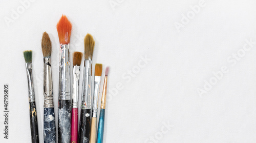 Group of artist brushes on white canvas background. Copy space