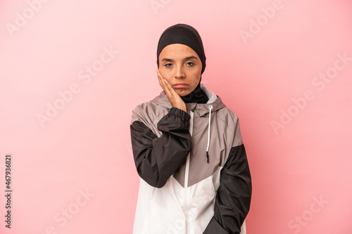 Young Arab woman with sport burqa isolated on pink background who is bored, fatigued and need a relax day.