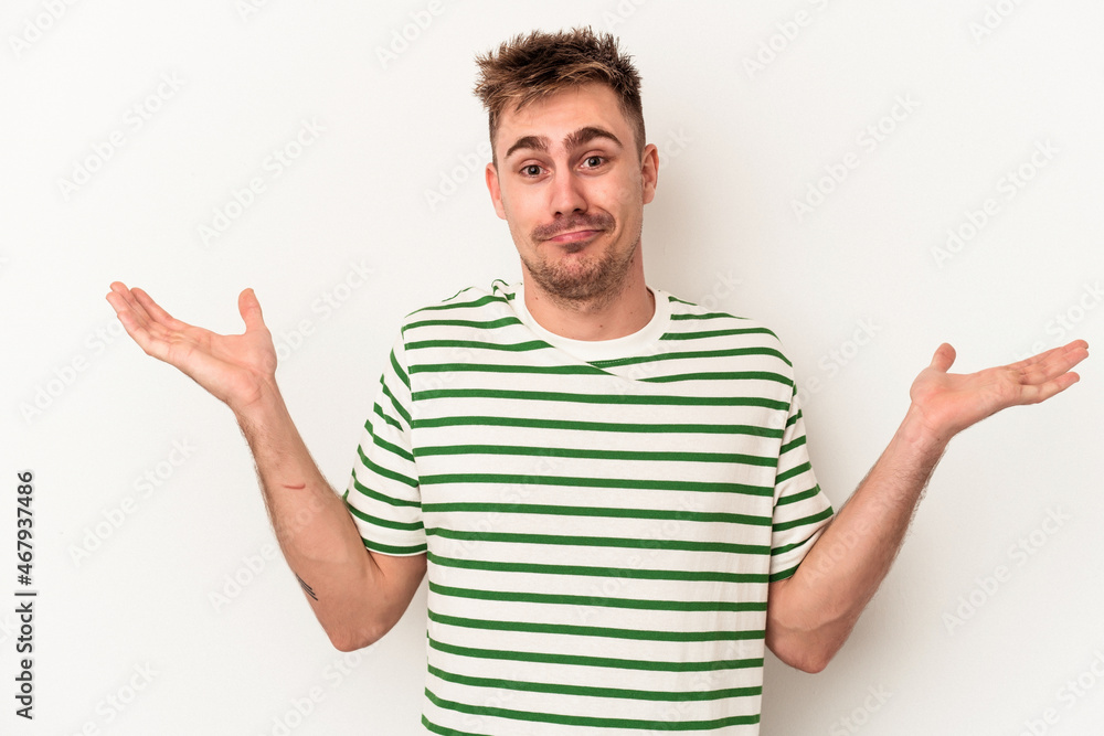 Young caucasian man isolated on white background doubting and shrugging shoulders in questioning gesture. Young caucasian man isolated on white background doubting and shrugging shoulders in questioning gesture.