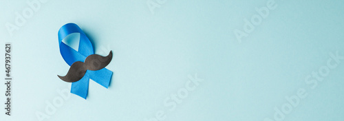 Top panoramic view photo of blue ribbon and mustache shape symbol of prostate cancer awareness on isolated pastel blue background with empty space photo