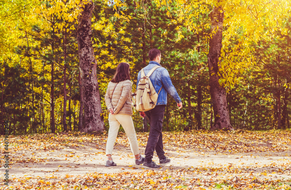 Fototapeta premium A guy and a girl walk along the path in the city Park
