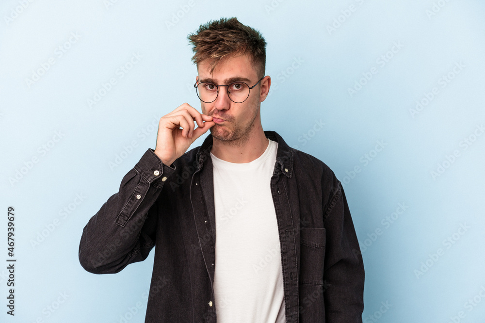Young caucasian man isolated on blue background with fingers on lips keeping a secret. Young caucasian man isolated on blue background with fingers on lips keeping a secret.
