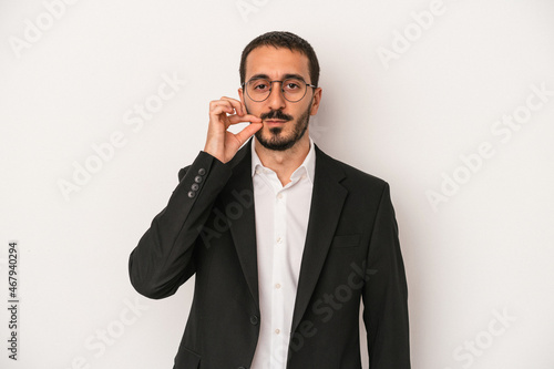 Young caucasian business man isolated on white background with fingers on lips keeping a secret. © Asier