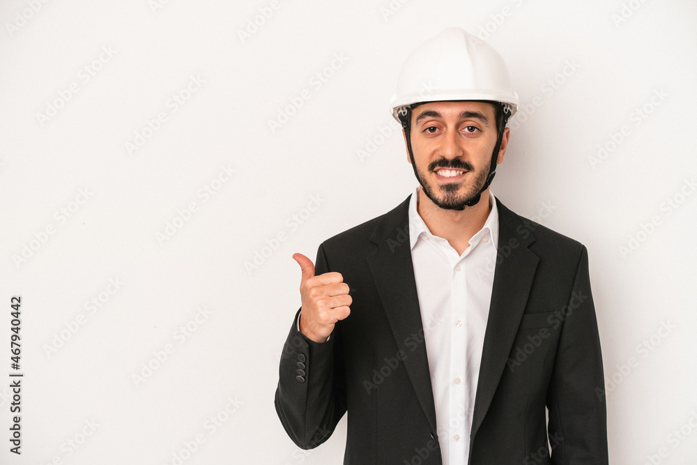 Young architect man wearing a construction helmet isolated on white background smiling and raising thumb up Young architect man wearing a construction helmet isolated on white background smiling and raising thumb up