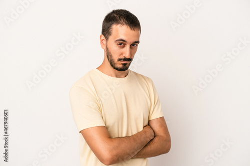 Young caucasian man isolated on white background suspicious, uncertain, examining you. © Asier
