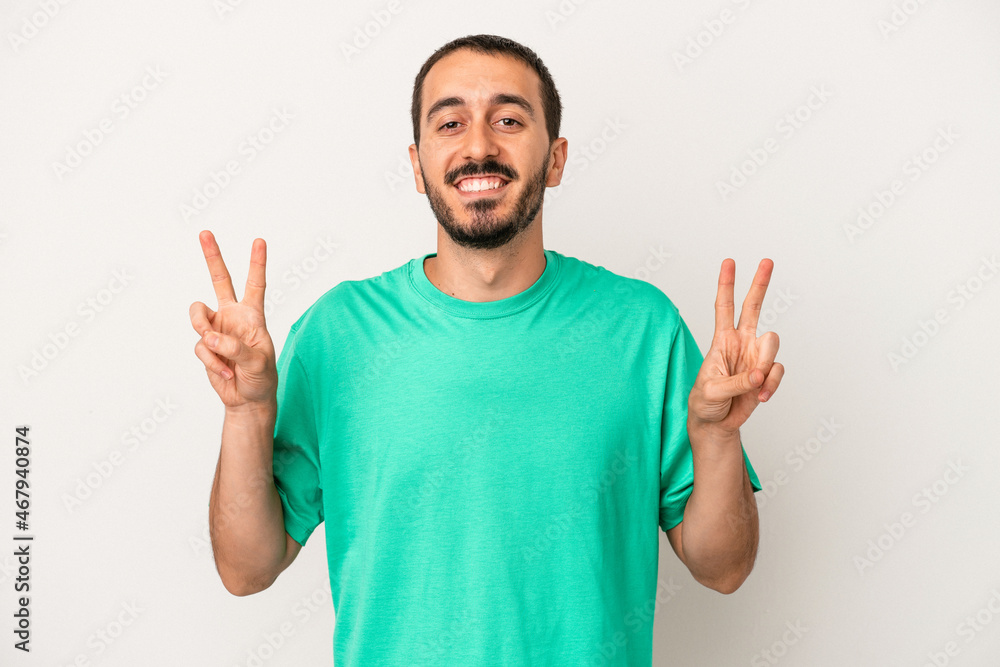 Young caucasian man isolated on white background showing victory sign and smiling broadly. Young caucasian man isolated on white background showing victory sign and smiling broadly.