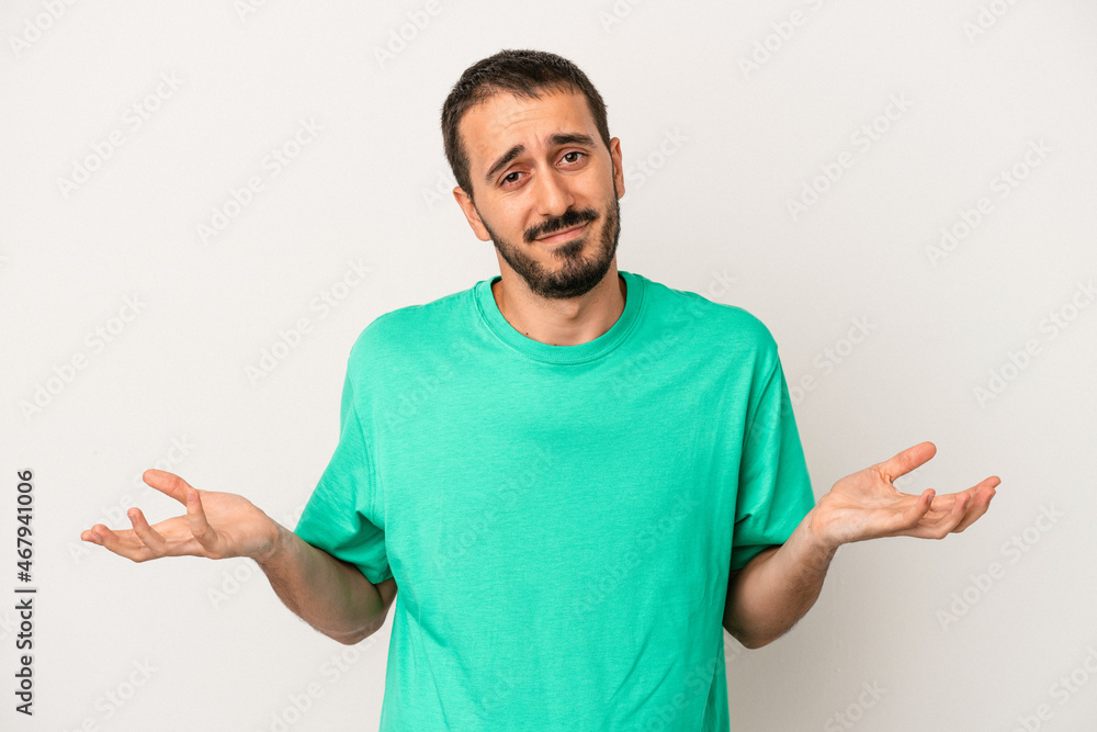 Young caucasian man isolated on white background doubting and shrugging shoulders in questioning gesture. Young caucasian man isolated on white background doubting and shrugging shoulders in questioning gesture.