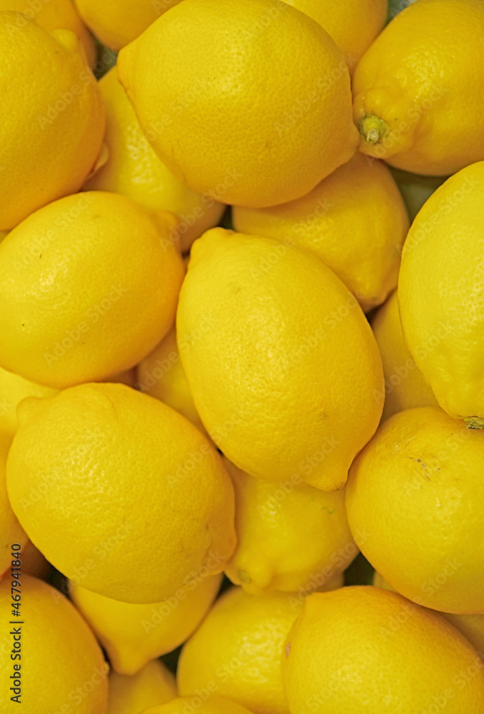 Pile of fresh ripe vibrant yellow lemons for backdrop or banner Pile of fresh ripe vibrant yellow lemons for backdrop or banner