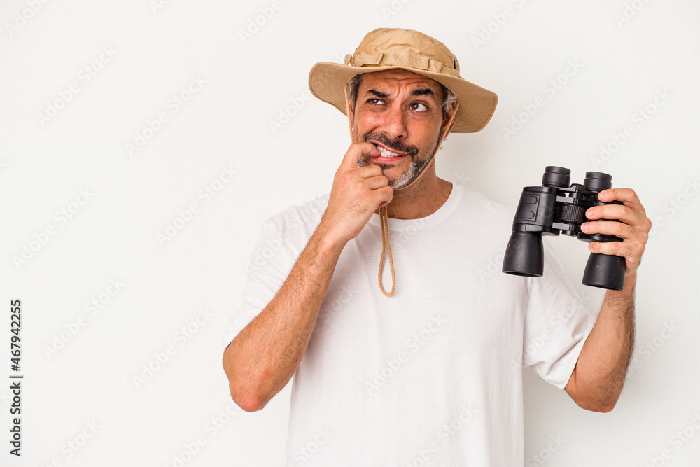 Middle age caucasian man holding binoculars isolated on white background relaxed thinking about something looking at a copy space. Middle age caucasian man holding binoculars isolated on white background relaxed thinking about something looking at a copy space.