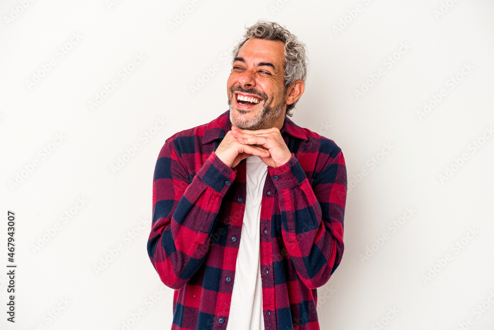 Middle age caucasian man isolated on white background keeps hands under chin, is looking happily aside. Middle age caucasian man isolated on white background keeps hands under chin, is looking happily aside.
