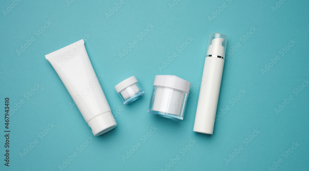 jar, bottle and empty white plastic tubes for cosmetics on a blue background. Packaging for cream, gel, serum, advertising and product promotion jar, bottle and empty white plastic tubes for cosmetics on a blue background. Packaging for cream, gel, serum, advertising and product promotion