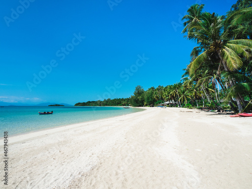 Peaceful white sand beach tropical island with turquoise water, coconut palm tree and local fishing boat. Koh Mak Island, Trat Province, Thailand.