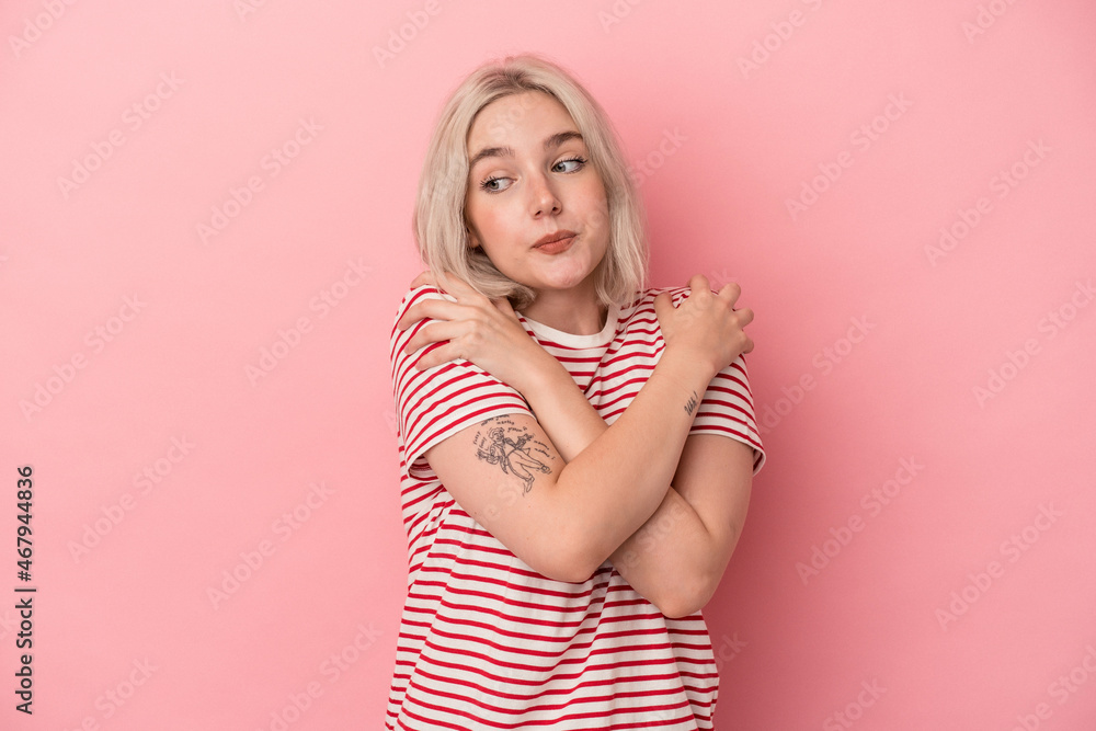 Young caucasian woman isolated on pink background hugs, smiling carefree and happy. Young caucasian woman isolated on pink background hugs, smiling carefree and happy.