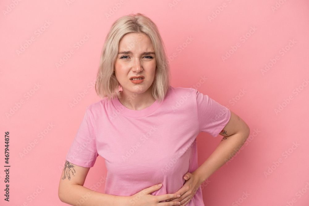 Young caucasian woman isolated on pink background having a liver pain, stomach ache. Young caucasian woman isolated on pink background having a liver pain, stomach ache.