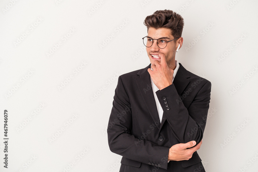 Young business caucasian man wearing headphones isolated on white background relaxed thinking about something looking at a copy space. Young business caucasian man wearing headphones isolated on white background relaxed thinking about something looking at a copy space.