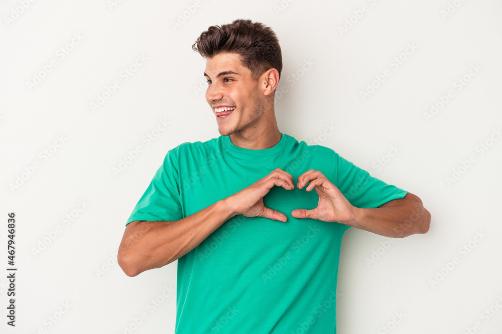 Young caucasian man isolated on white background smiling and showing a heart shape with hands. Young caucasian man isolated on white background smiling and showing a heart shape with hands.