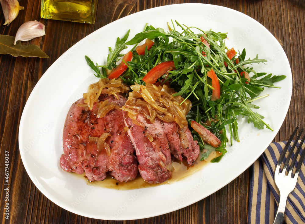 Fine Meat - Boiled Cured Veal Tongue Meat Slices with roasted Onions and Salad on wooden Background Fine Meat - Boiled Cured Veal Tongue Meat Slices with roasted Onions and Salad on wooden Background