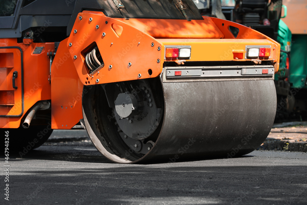 Modern roller on city street, closeup. Road repair service Modern roller on city street, closeup. Road repair service