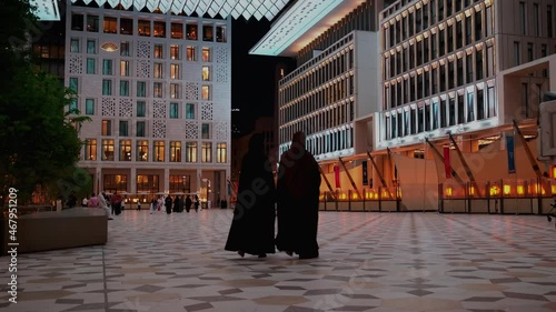 Msheireb Downtown in Doha , Qatar night shot  showing the unique architecture of the buildings with locals and visitors  walking