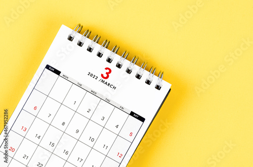 March 2022 desk calendar on yellow background.