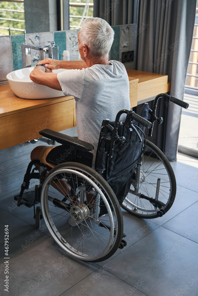 Aging male who lives with disability washing his hands