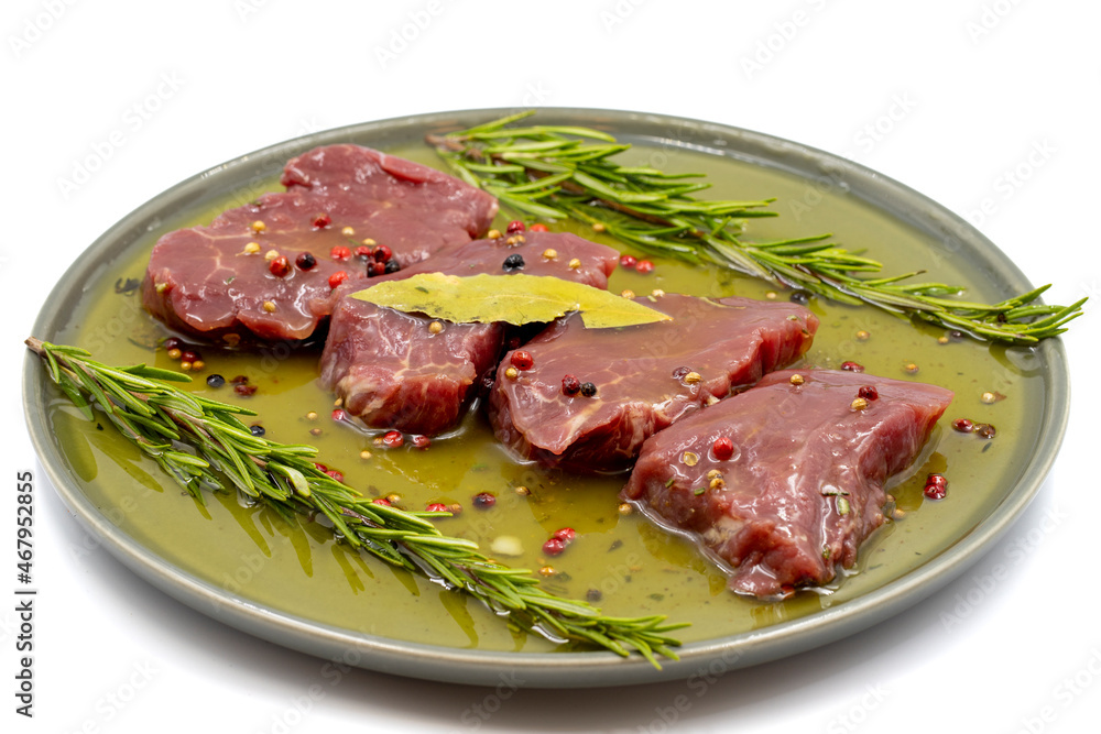 Marinated beef tenderloin on a white background. Beef tenderloin marinated with olive oil and various spices Marinated beef tenderloin on a white background. Beef tenderloin marinated with olive oil and various spices