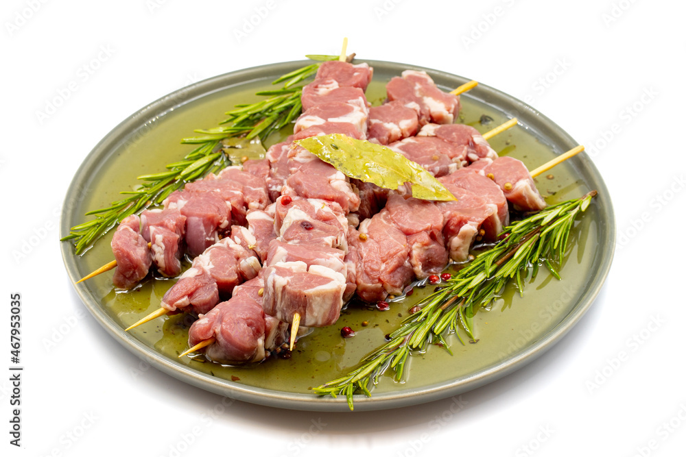 Marinated raw lamb skewers on a white background. Lamb skewers marinated in olive oil and various spices