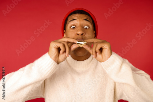 Fotografie A dark-skinned man in santa hat with a beep tongue