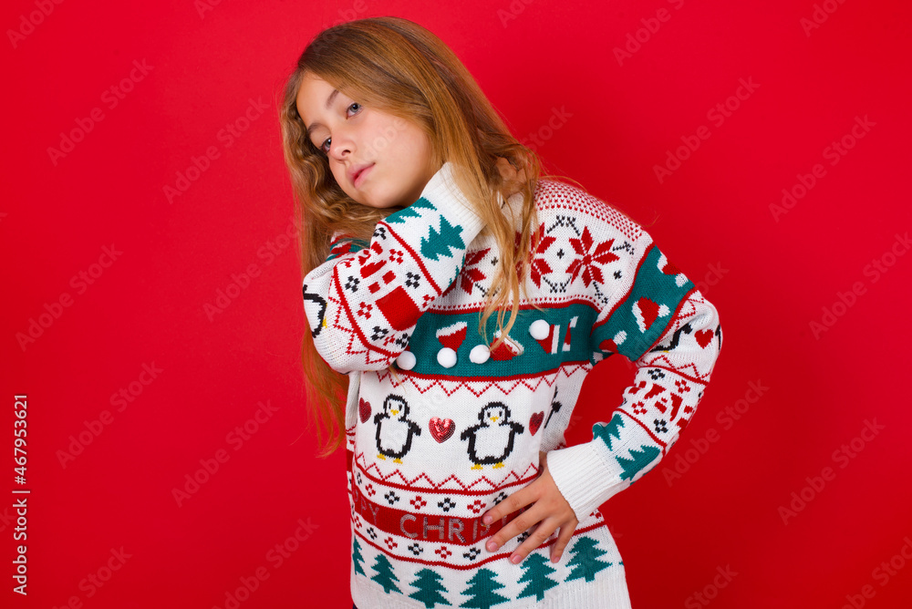 brunette kid girl in knitted sweater christmas over red background got back pain brunette kid girl in knitted sweater christmas over red background got back pain