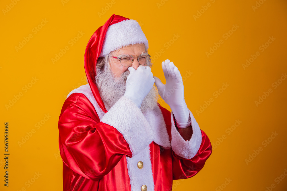 Santa Claus isolated against yellow background, smelling something