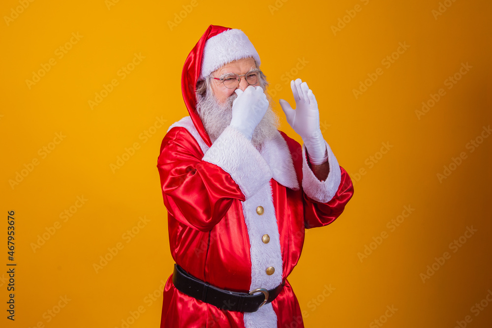 Santa Claus isolated against yellow background, smelling something
