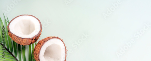 Beautiful composition with coconuts and tropical leaves on green background. Spa concept. Banner. Copy space