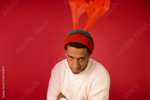 A man in swhites sweater and with reindeer antlers photo