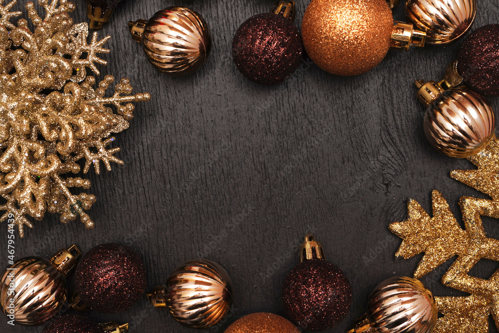 Christmas decorative composition with gold shiny snowflakes, christmas golden balls on black wood background. Christmas or New Year concept. Festive Christmas background with baubles and copy space. Christmas decorative composition with gold shiny snowflakes, christmas golden balls on black wood background. Christmas or New Year concept. Festive Christmas background with baubles and copy space.