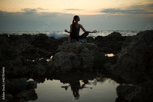 Caucasian woman practicing yoga at seashore of ocean