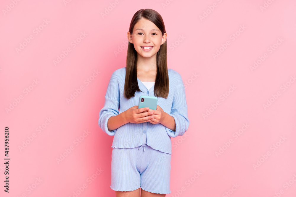 Photo of pretty charming school girl dressed blue clothes smiling communicating modern gadget isolated pink color background Photo of pretty charming school girl dressed blue clothes smiling communicating modern gadget isolated pink color background