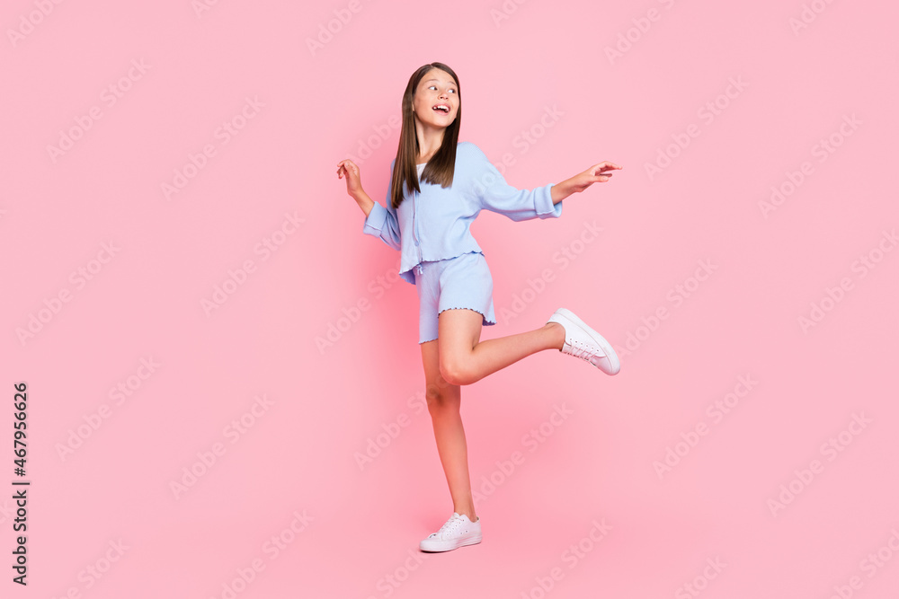 Photo of funny beautiful school girl dressed blue clothes smiling dancing isolated pink color background
