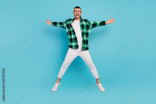 Full body photo of happy cool cheerful man jump star shape fly good mood enjoy isolated on blue color background © deagreez