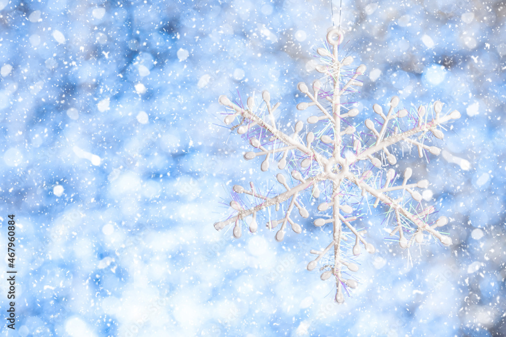 Snowflake in the snow. White snowflake on a blurred shiny white-blue background. Copy space. Template for design Snowflake in the snow. White snowflake on a blurred shiny white-blue background. Copy space. Template for design