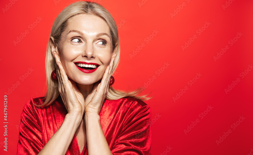 Holidays and women beauty concept. Smiling beautiful woman 50 years, mature lady with perfect skin and smile, looking aside happy, posing for Christmas advertisement Holidays and women beauty concept. Smiling beautiful woman 50 years, mature lady with perfect skin and smile, looking aside happy, posing for Christmas advertisement