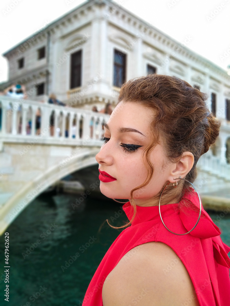 Venice, Italy. Yang beautiful model Lagy in Red. Portrait of a shaten gypsy girl with red lips and big brown eyes. Large round earrings