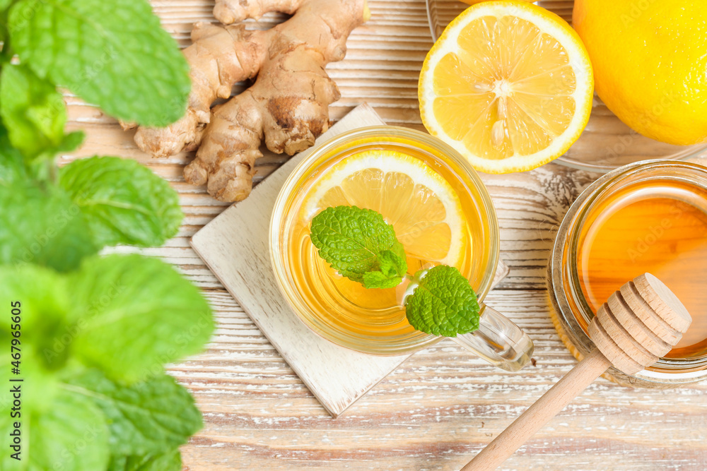 Tea with lemon, ginger root, honey and mint leaves top view on wooden background Tea with lemon, ginger root, honey and mint leaves top view on wooden background