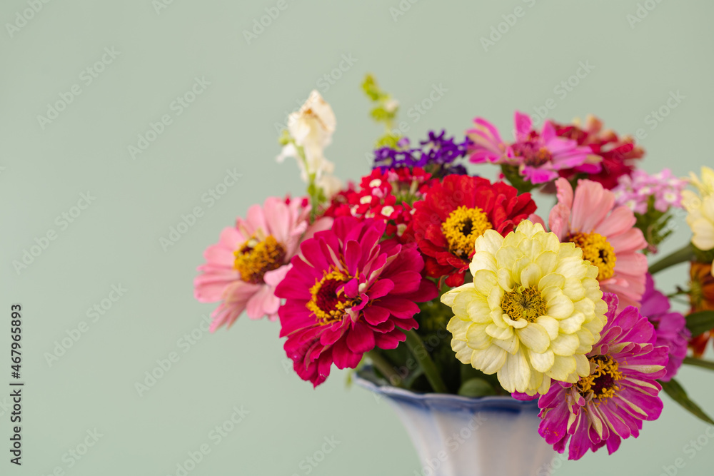 Bouquet of rose flowers in modern vase on table.