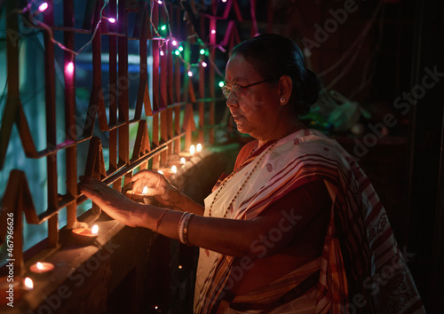 A Hindu woman decorating her home with lighting earthen lamps (or diyas) on the evening of Diwali and Kali puja. Kali Puja is a Hindu Festival of light, mostly popular with Bengali communities.