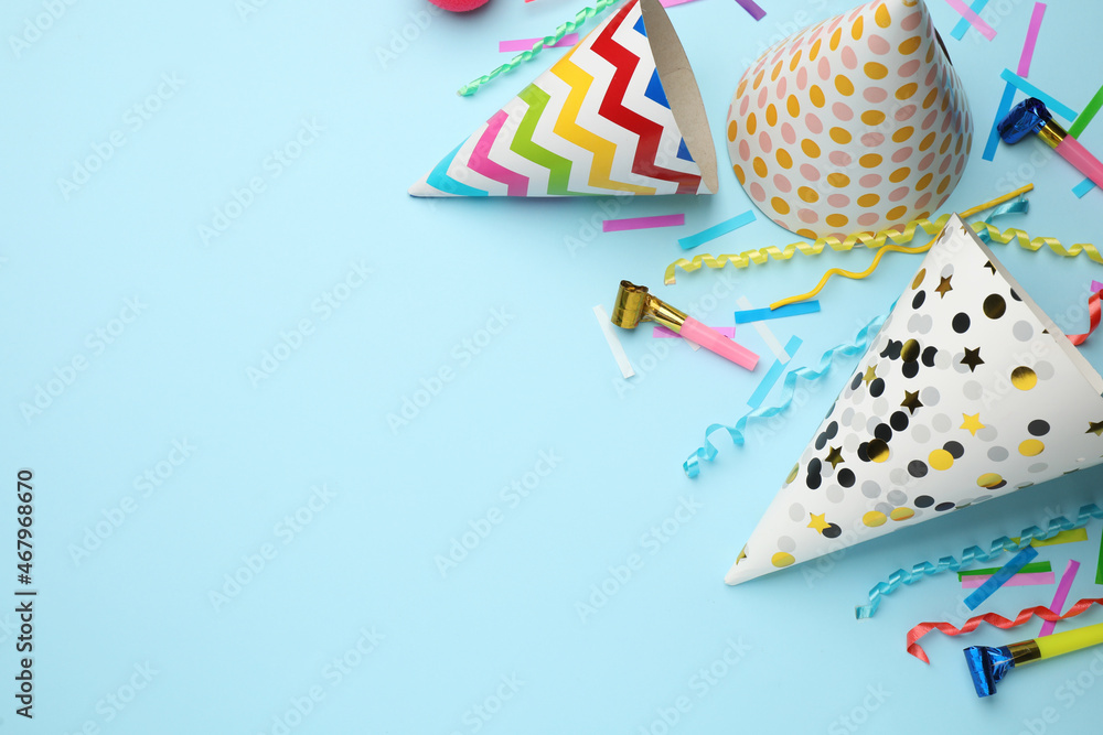 Obraz premium Flat lay composition with party hats and other festive items on light blue background. Space for text