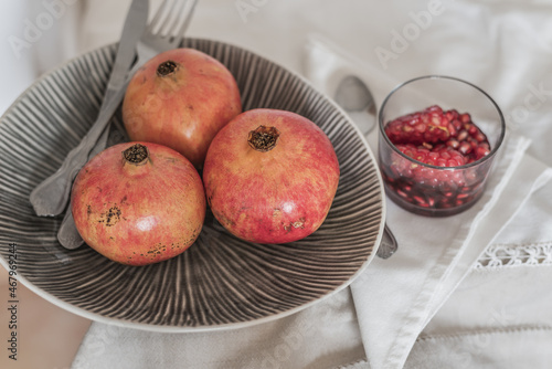 fruit still life. Pomegranates in fruit bowl and peeled fruit in glass with wine ready to eat.