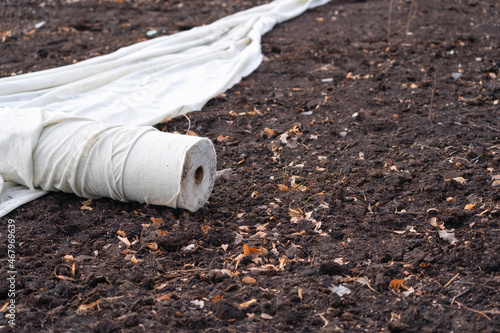 A roll of rolled white geotextile on the ground. photo